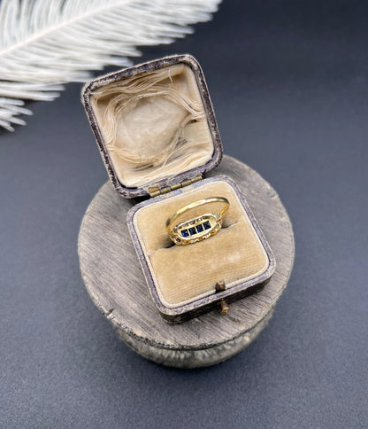 A sapphire and diamond elongated cluster ring in platinum and yellow gold, in an antique ring box