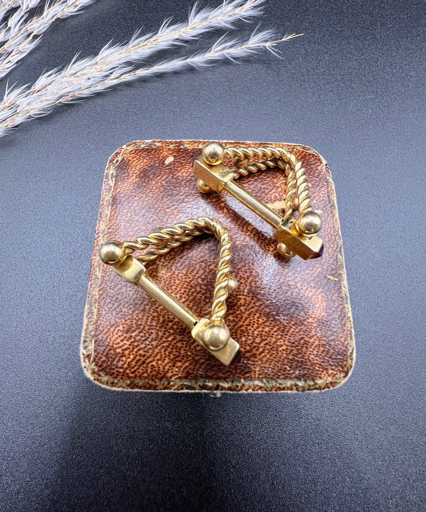 A pair of yellow gold ruby cufflinks, on an antique box
