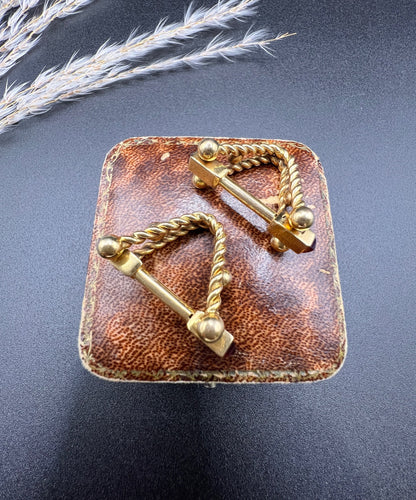 A pair of yellow gold ruby cufflinks, on an antique box