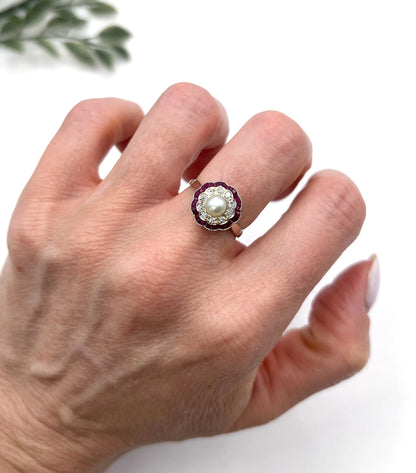 A pearl, diamond and ruby fancy cluster ring in platinum and yellow gold, modelled on a hand
