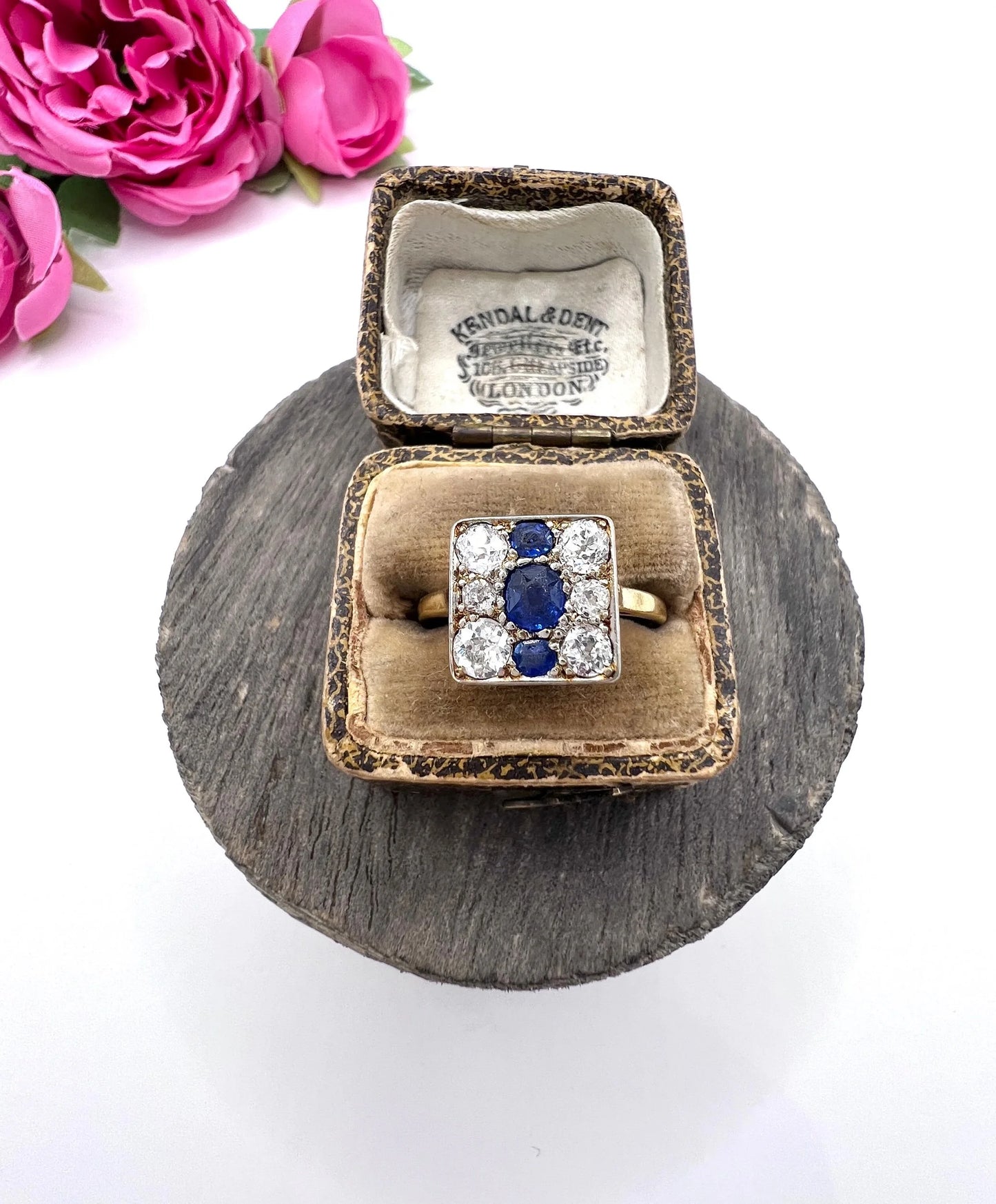 A square-shaped cluster ring with sapphires and diamonds in yellow gold and platinum, in an antique ring box