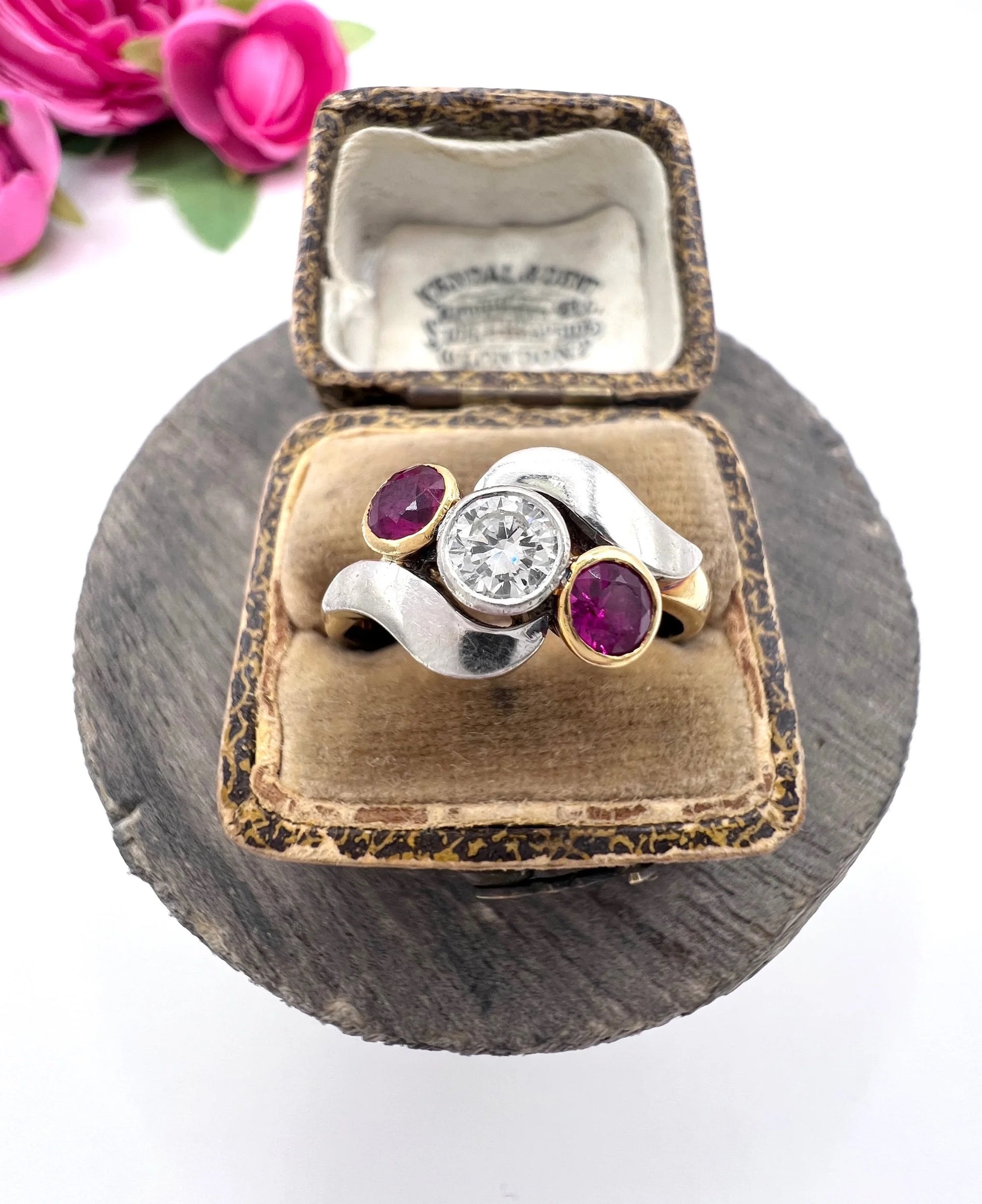 A three stone ruby and diamond crossover ring in platinum and yellow gold, in a ring box