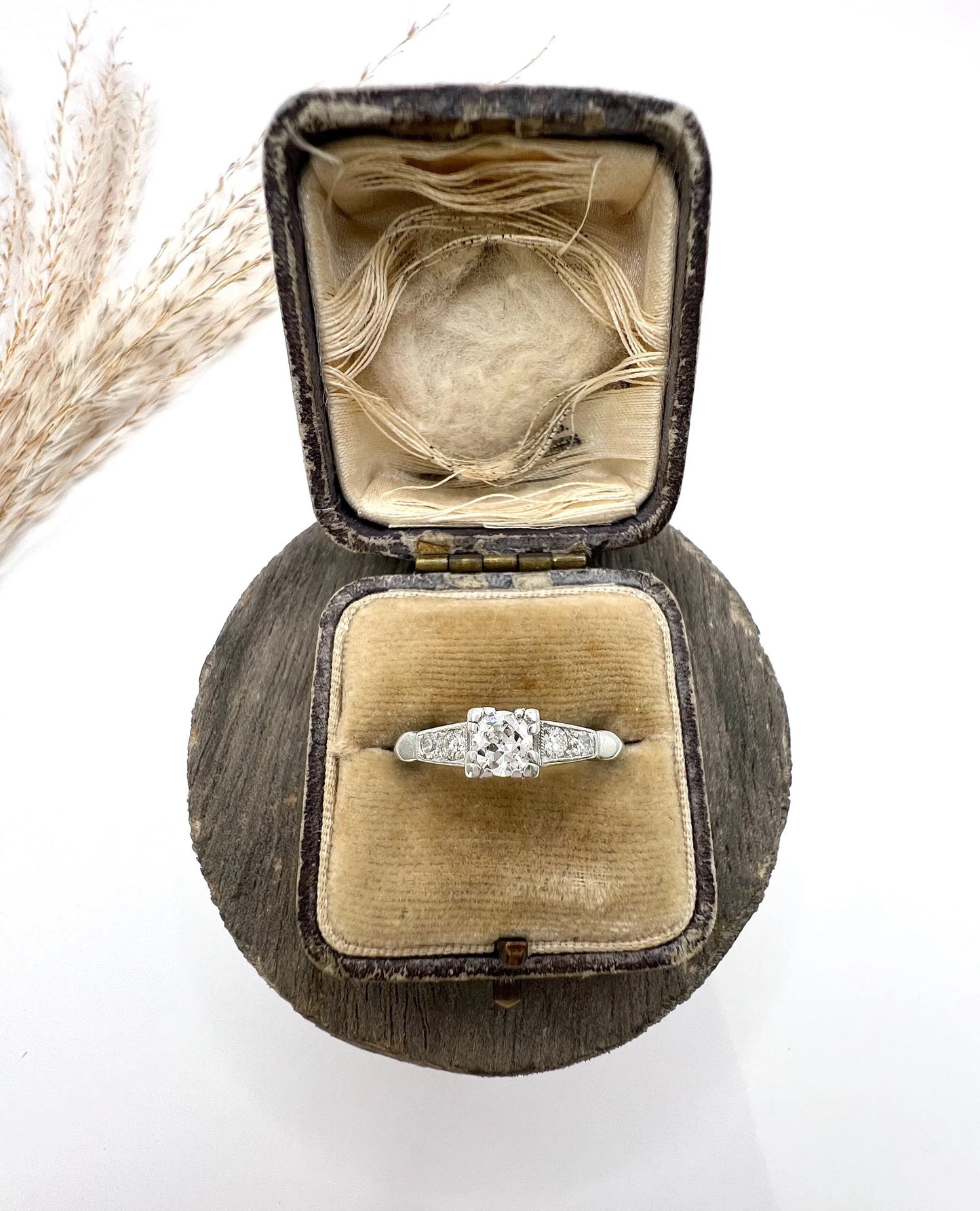 A solitaire diamond ring in platinum, with diamond set shoulders, in a ring box