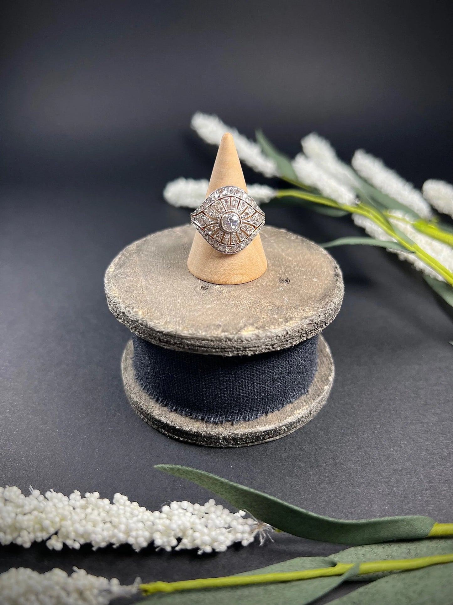 A diamond cocktail ring in yellow and white metal, on a ring cone