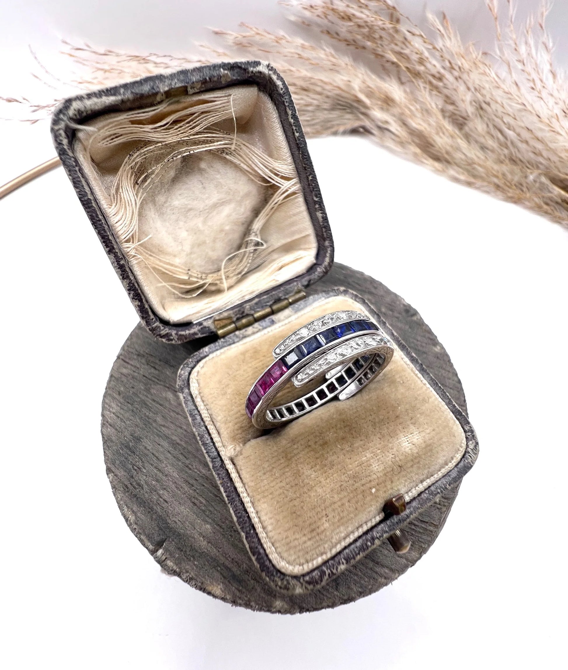 A platinum night and day flip band ring set with diamonds, sapphires and rubies, in a ring box