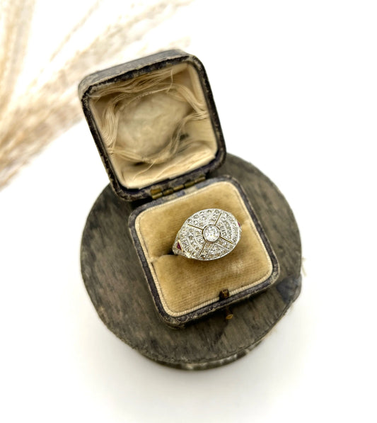 A diamond oval shaped bombé design ring, in an antique ring box