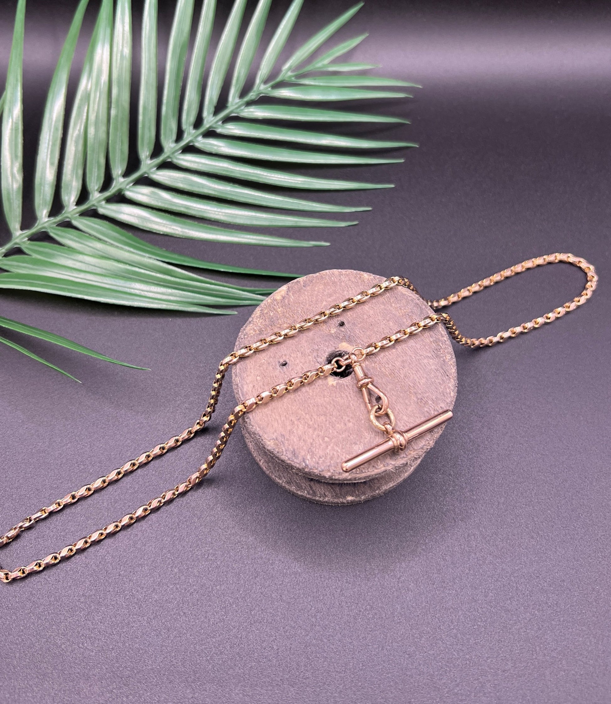 A rose gold tulip link chain necklace with a dog clip clasp and T-bar