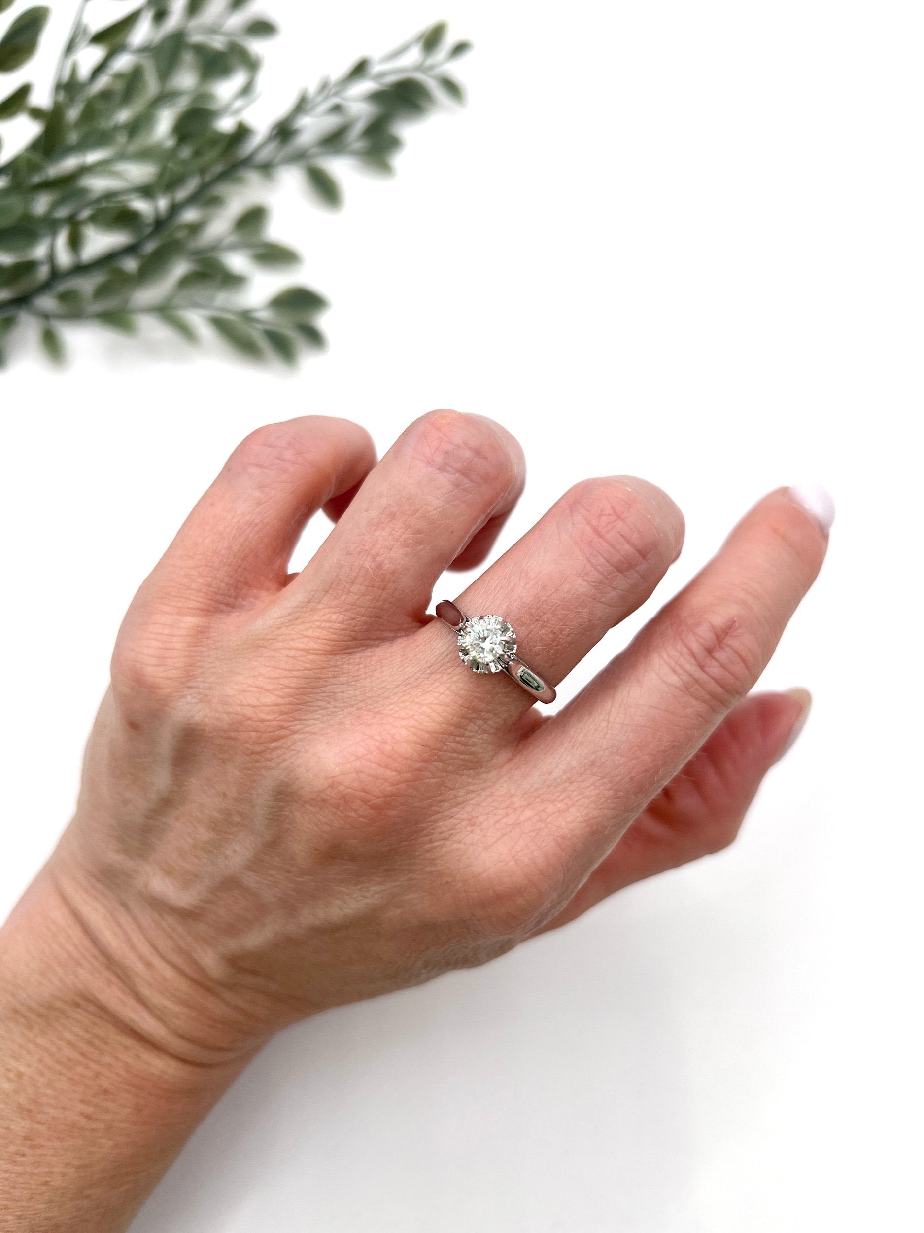 A solitaire round diamond ring in white gold, modelled on a hand