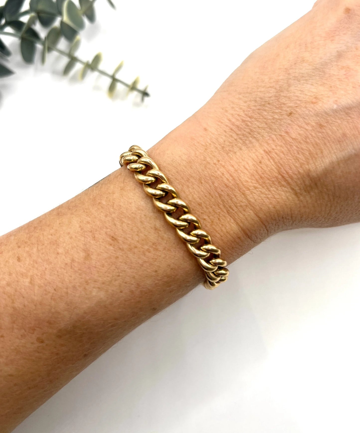 A curb link bracelet in yellow gold, modelled on a wrist