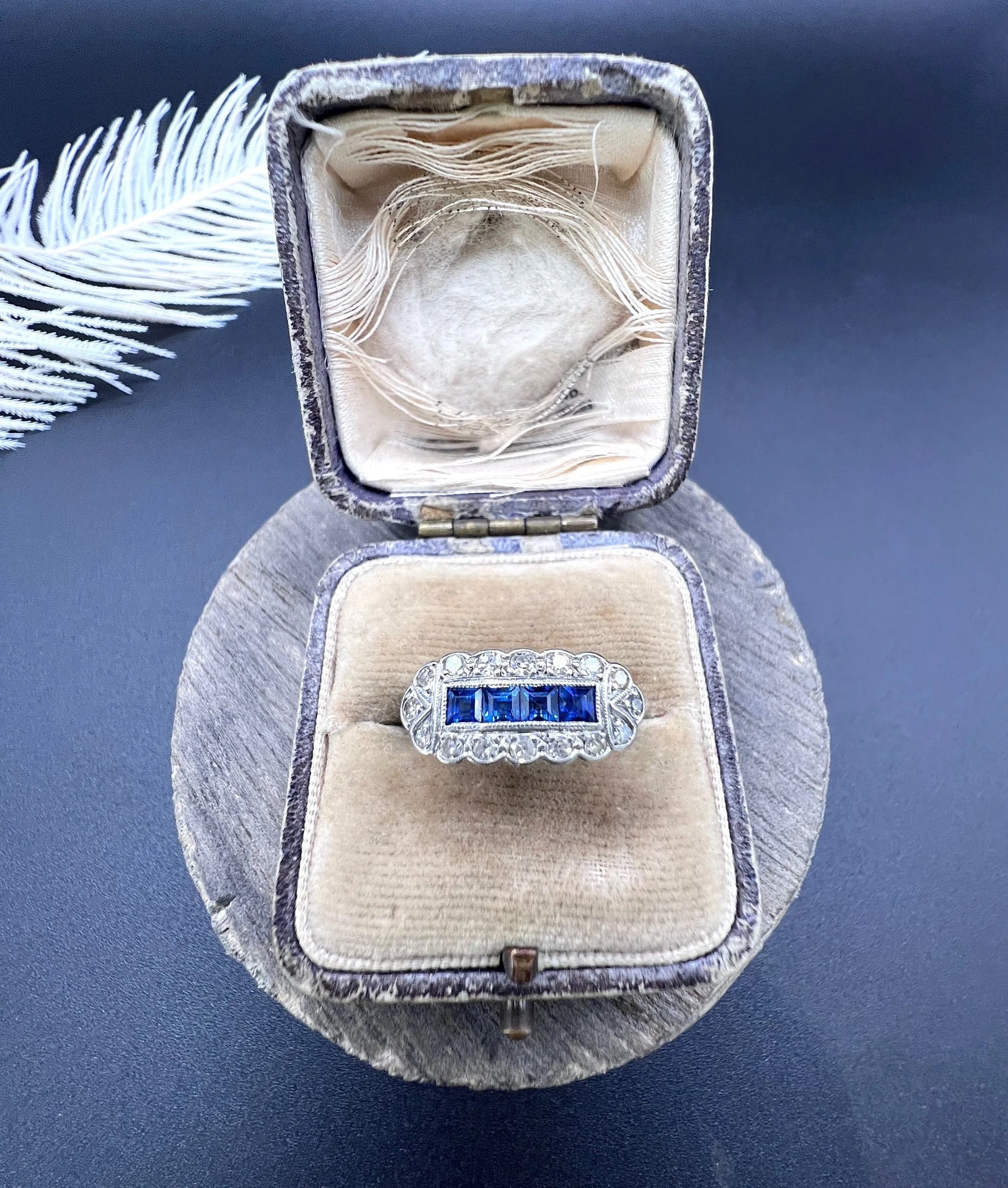 A sapphire and diamond elongated cluster ring in platinum and yellow gold, in an antique ring box