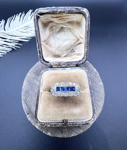 A sapphire and diamond elongated cluster ring in platinum and yellow gold, in an antique ring box