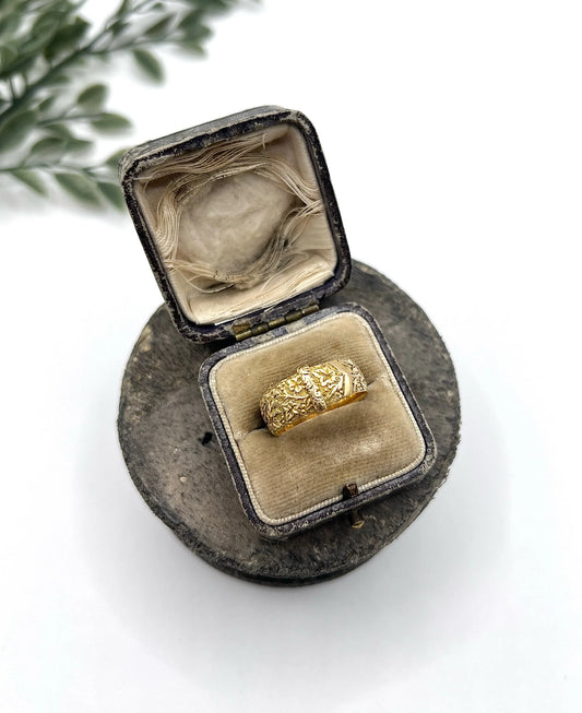 A yellow gold ornate engraved buckle band ring, in an antique ring box