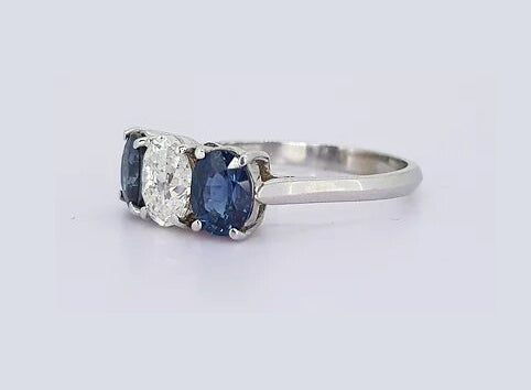Sapphire and Diamond Three Stone Ring, classic trilogy ring featuring, 0.75ct oval-cut diamond flanked by 1.75cts oval sapphires, claw set, 18ct white gold.