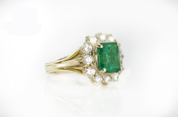 Vintage 3.80ct Natural Colombian Emerald and Diamond Cluster Ring; central 3.80 carat octagonal-cut emerald surrounded by 1.20cts diamonds, 18ct yellow gold, with GCS certificate. Circa 1970's