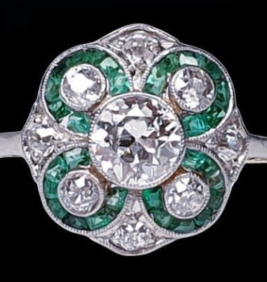 Antique Edwardian Emerald and Diamond Floral Cluster Dress Ring; old European transitional cut diamonds with calibre emeralds set into circular floral swirls, 1.00 carat total, in platinum with 18ct gold engraved sides, Swedish, Circa 1900