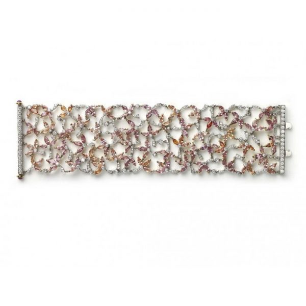 Padparadscha Sapphire, Diamond and Ruby Bracelet; set with 39.52cts pink, orange and red, marquise-cut padparadscha sapphires, decorated with 6.14cts round brilliant-cut diamonds. Accented with cabochon-cut ruby set terminals on the clasp. Mounted in platinum and 18ct yellow gold