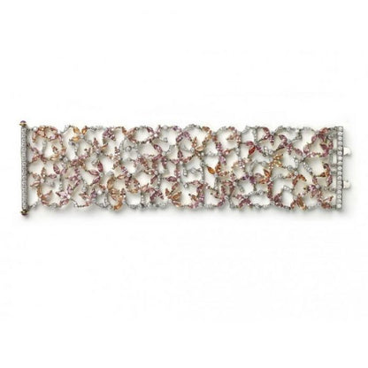 Padparadscha Sapphire, Diamond and Ruby Bracelet; set with 39.52cts pink, orange and red, marquise-cut padparadscha sapphires, decorated with 6.14cts round brilliant-cut diamonds. Accented with cabochon-cut ruby set terminals on the clasp. Mounted in platinum and 18ct yellow gold