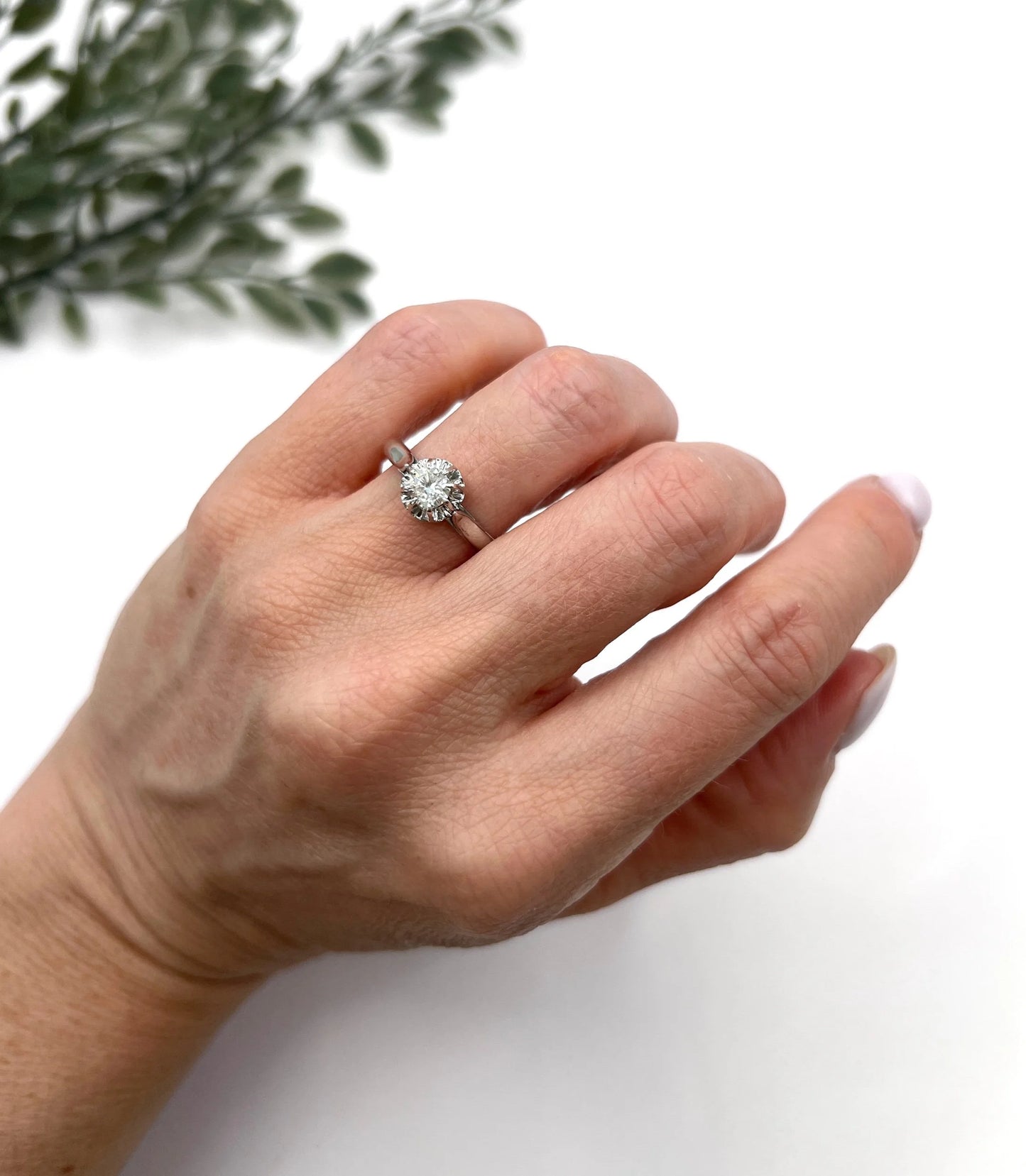 A solitaire round diamond ring in white gold, modelled on a hand