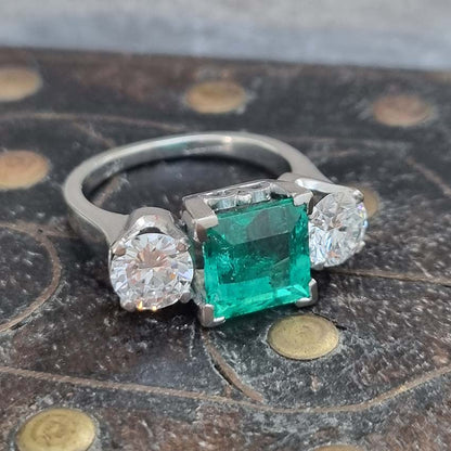 2.36ct Square Step Cut Emerald and 1.50ct Diamond Three Stone Trilogy Engagement Ring in 18ct White Gold