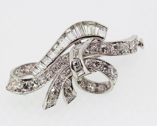 Vintage Diamond Bow Brooch; classic vintage bow brooch set with brilliant-cut and baguette-cut diamonds. Crafted from 18ct white gold