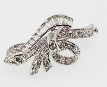 Vintage Diamond Bow Brooch; classic vintage bow brooch set with brilliant-cut and baguette-cut diamonds. Crafted from 18ct white gold