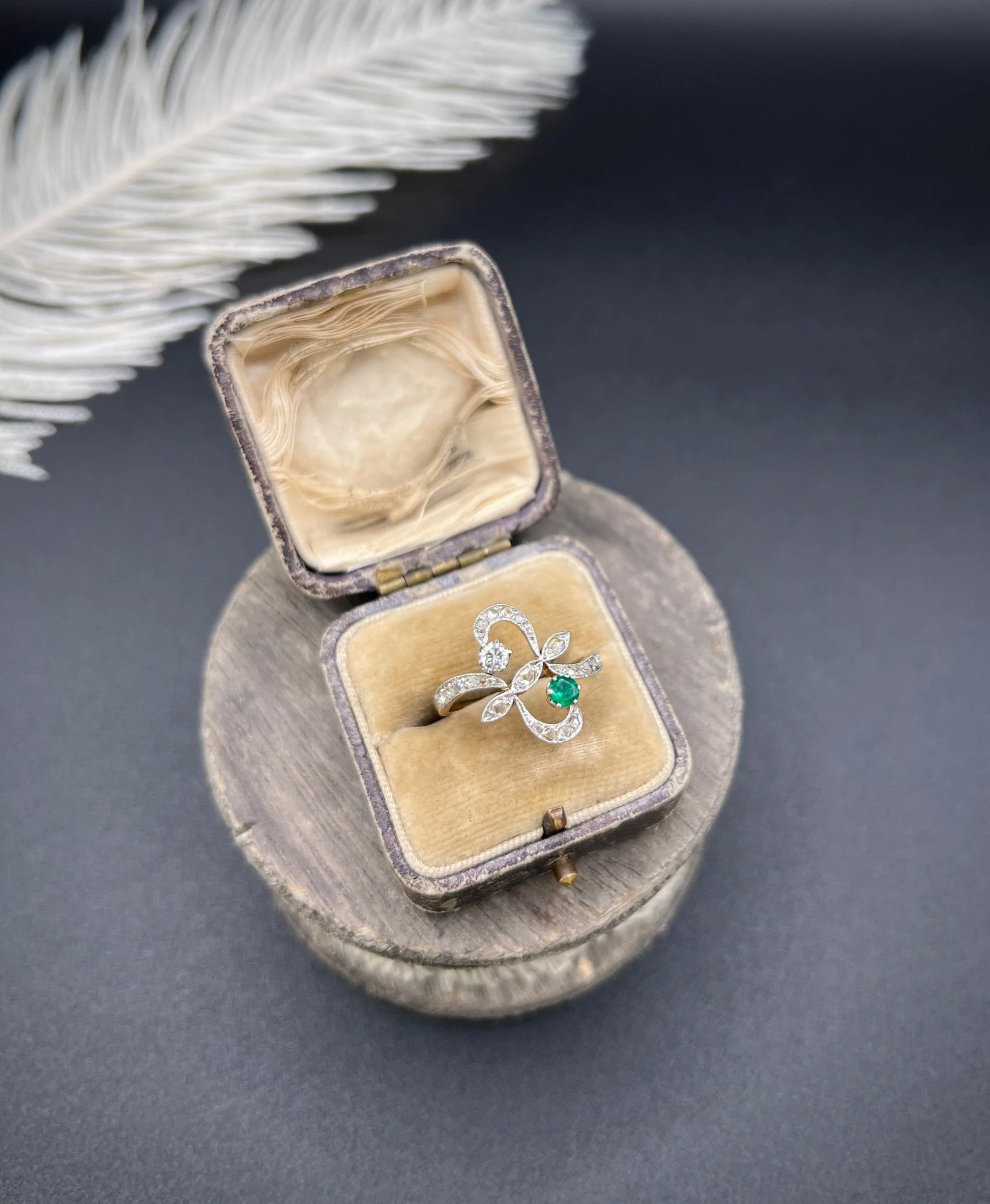 An emerald and diamond fancy openwork ring in yellow gold and platinum, in an antique ring box