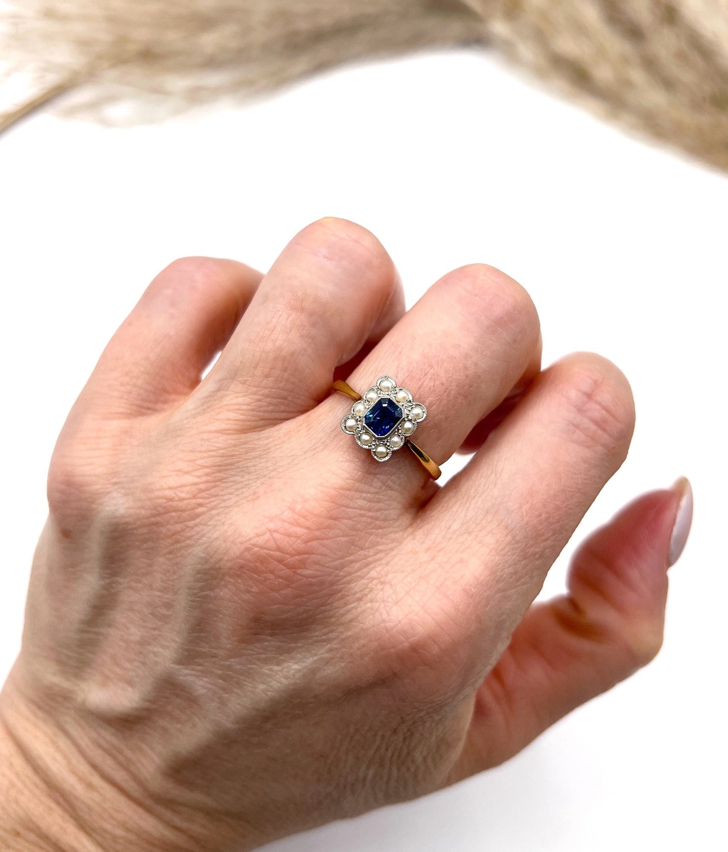 A sapphire and pearl cluster ring in yellow gold and platinum, modelled on a hand