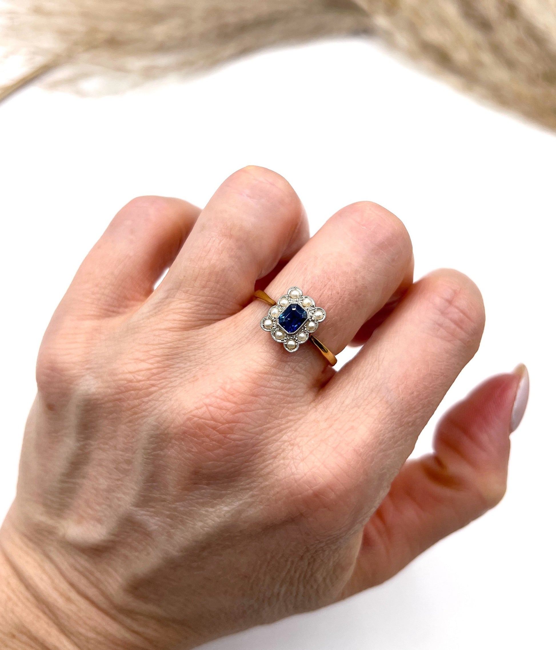 A sapphire and pearl cluster ring in yellow gold and platinum, modelled on a hand