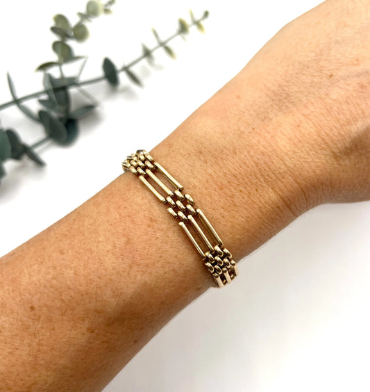 A yellow gold gate style bracelet, modelled on a wrist