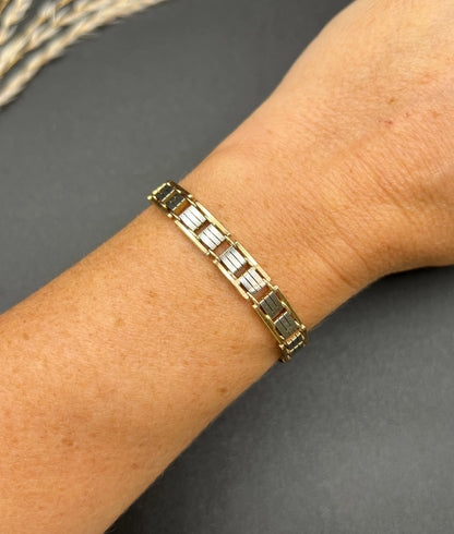 A gold and platinum gate bracelet, modelled on a wrist