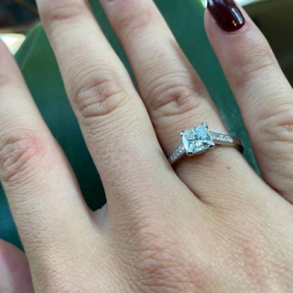 A diamond engagement ring, set with a 1.03 carat, F colour, VS1 clarity, princess-cut diamond, diamond set shoulders, in platinum, with GIA certificate.