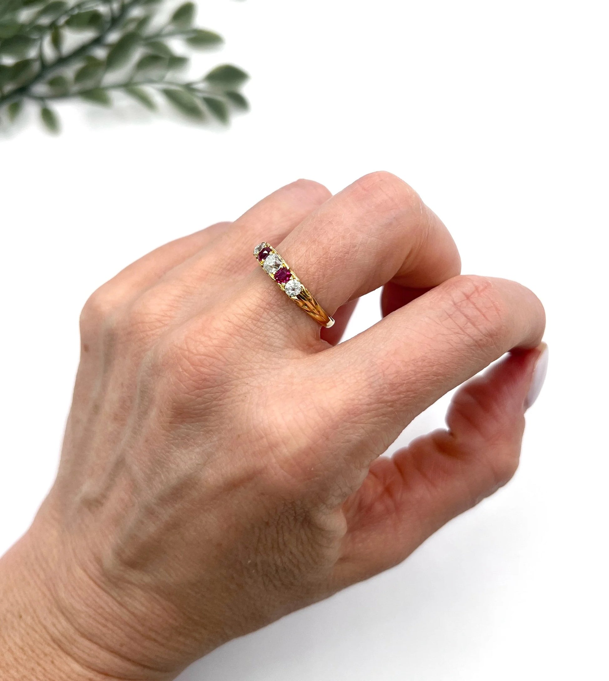 A yellow gold ruby and diamond five stone ring, modelled on a hand