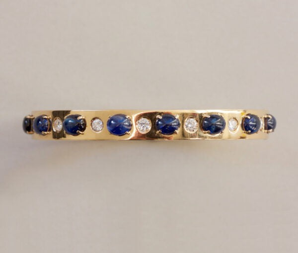 Vintage Sapphire, Diamond and 18ct Yellow Gold Bangle Bracelet; set with 7.00cts oval cabochon sapphires and 0.42cts brilliant cut diamonds