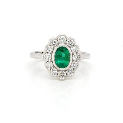 Oval Cut Zambian Emerald and Diamond Cluster Ring; oval 0.99ct Zambian emerald surrounded by brilliant-cut diamonds totalling 0.70cts. With certificate.