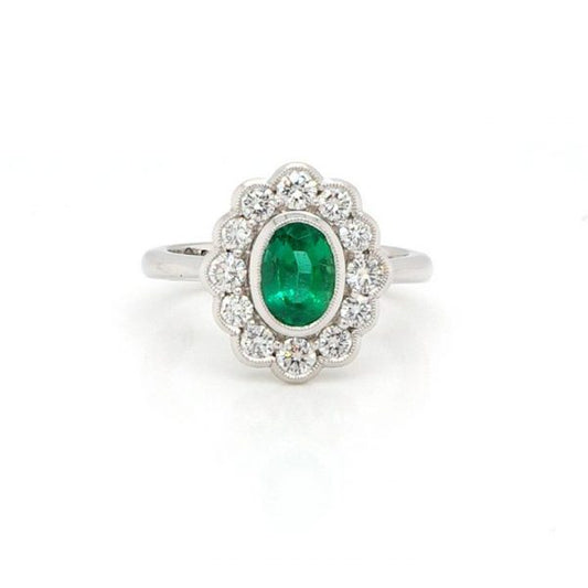 Oval Cut Zambian Emerald and Diamond Cluster Ring; oval 0.99ct Zambian emerald surrounded by brilliant-cut diamonds totalling 0.70cts. With certificate.