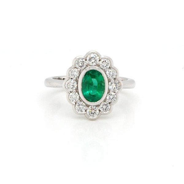 Oval Cut Zambian Emerald and Diamond Cluster Ring; oval 0.99ct Zambian emerald surrounded by brilliant-cut diamonds totalling 0.70cts. With certificate.