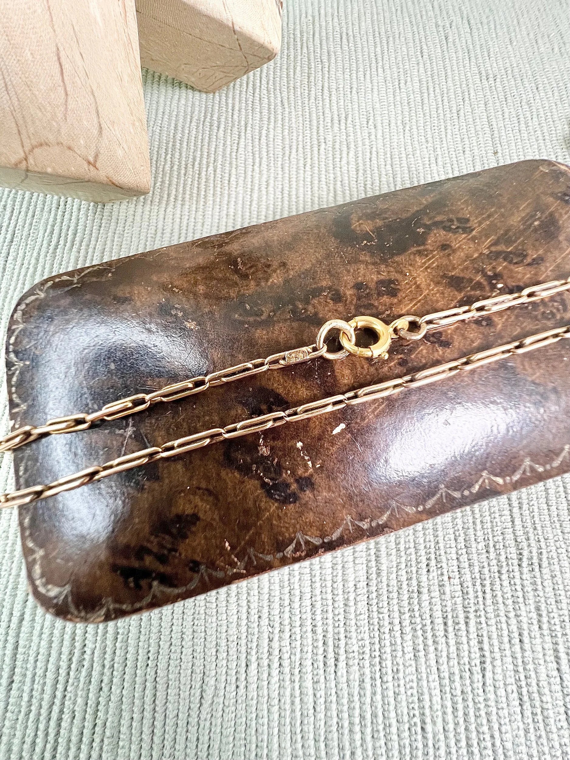 A gold paperclip link chain necklace