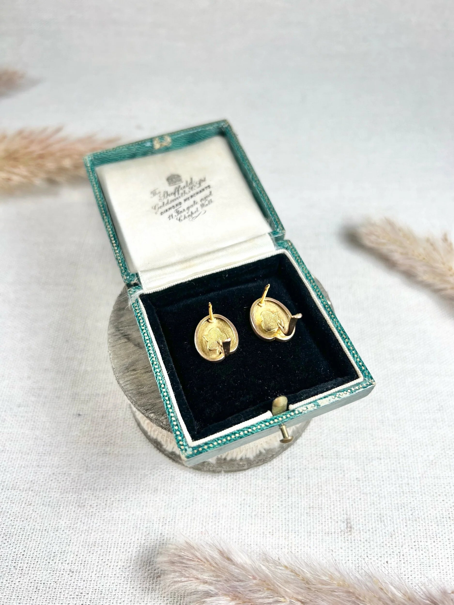 A pair of art palette shaped gold earrings, in a box