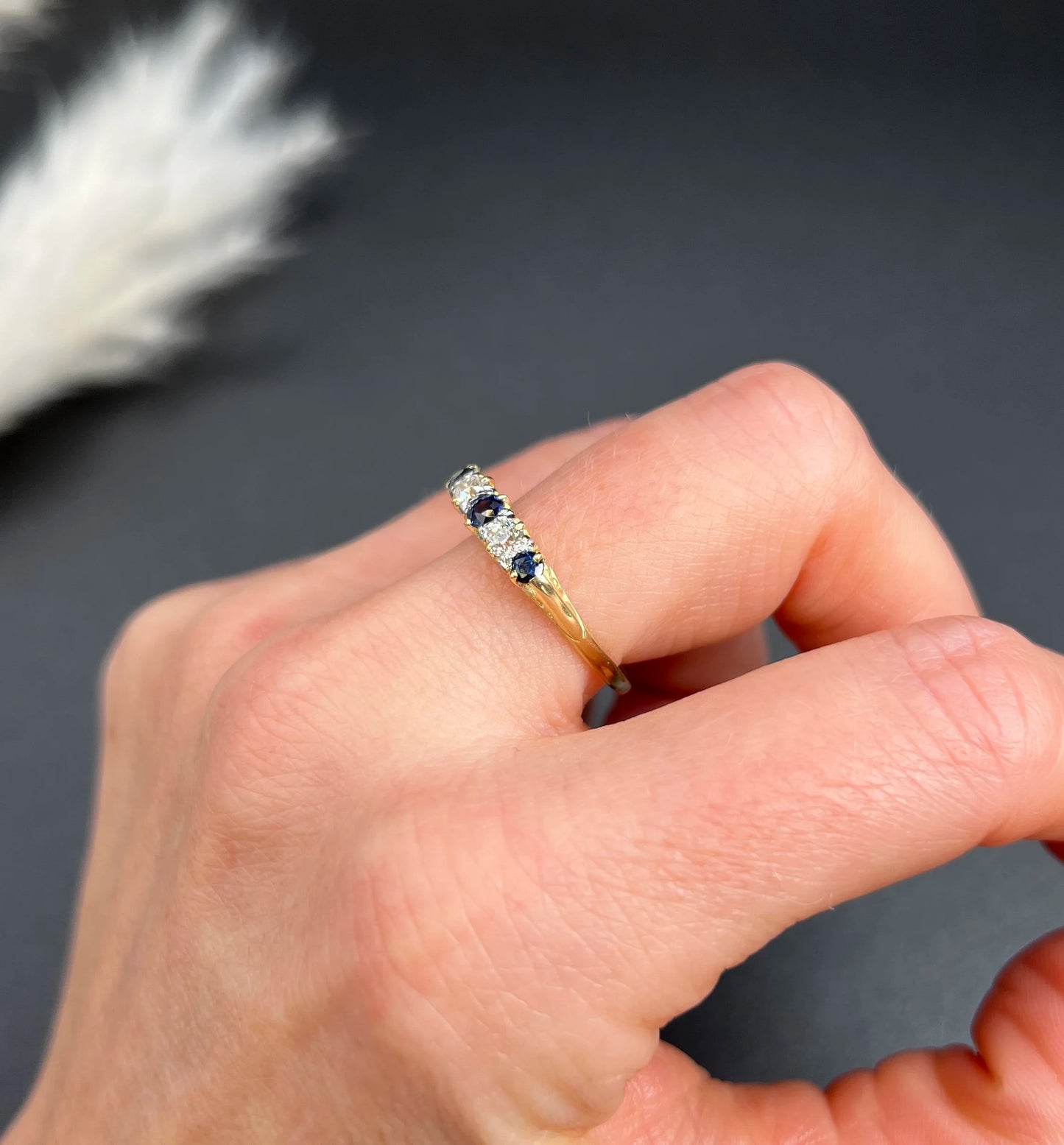 A yellow gold five stone sapphire and diamond carved half hoop ring, modelled on a hand