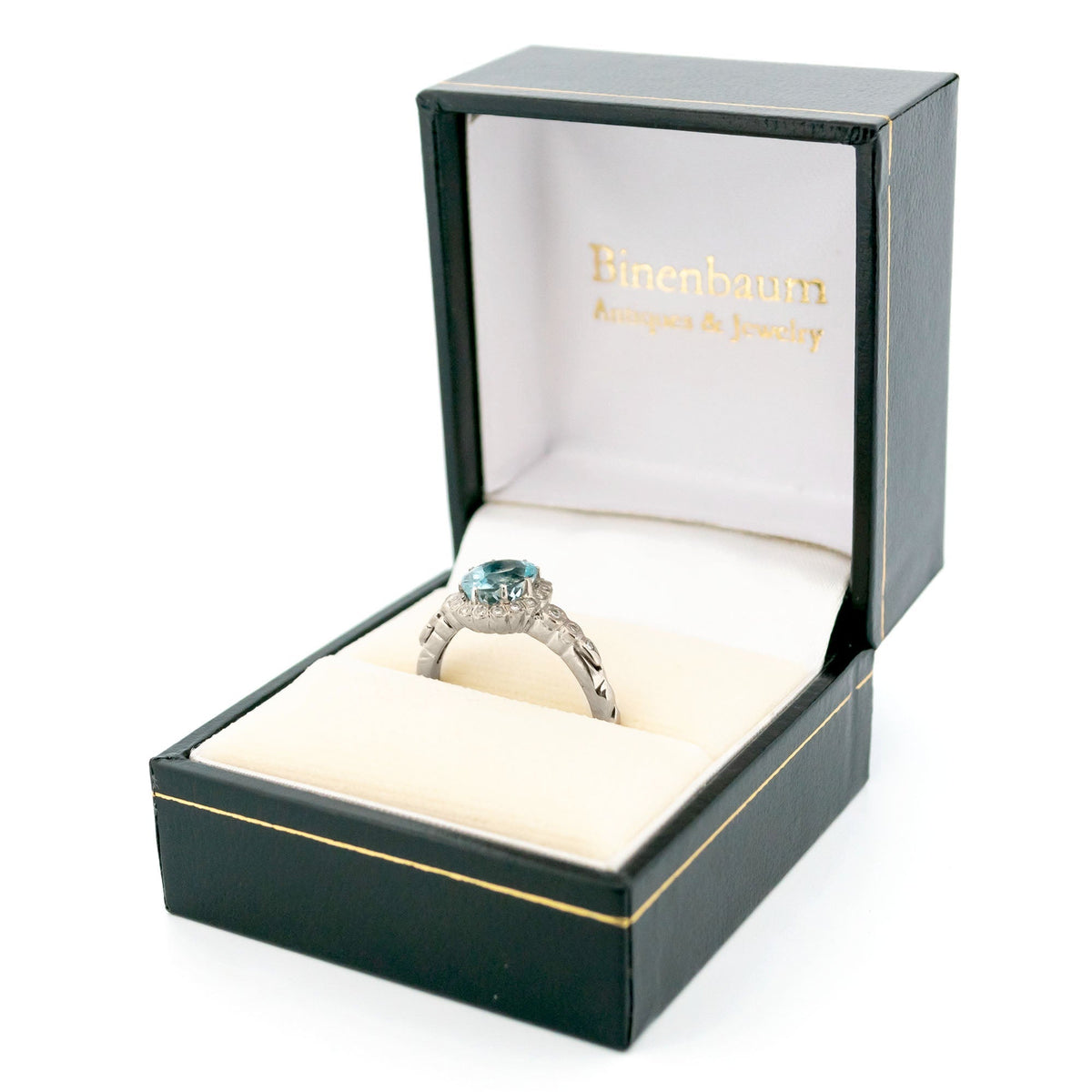 An oval aquamarine and round diamond cluster ring in white gold, in a ring box
