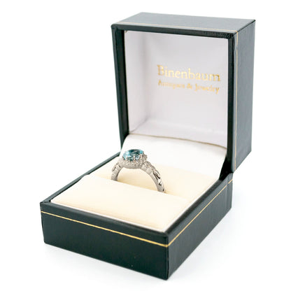 An oval aquamarine and round diamond cluster ring in white gold, in a ring box