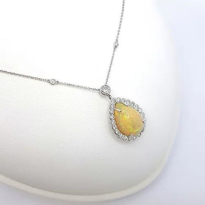 Opal and Diamond Pear Cluster Pendant Necklace; 10.00 carat pear-shaped cabochon-cut opal surrounded by 1.80cts diamonds, on a diamond set chain, in 18ct white gold
