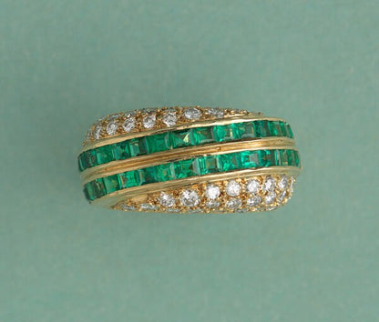Vintage Emerald and Diamond Asymmetric Band Ring; two diagonal stripes set with 1.92cts carré cut emeralds bordered by 1.30cts graduated brilliant cut diamonds on each side. Swiss made, Signed and retailed by David Morris, England