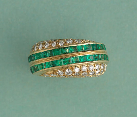 Vintage Emerald and Diamond Asymmetric Band Ring; two diagonal stripes set with 1.92cts carré cut emeralds bordered by 1.30cts graduated brilliant cut diamonds on each side. Swiss made, Signed and retailed by David Morris, England