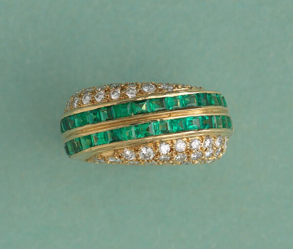 Vintage Emerald and Diamond Asymmetric Band Ring; two diagonal stripes set with 1.92cts carré cut emeralds bordered by 1.30cts graduated brilliant cut diamonds on each side. Swiss made, Signed and retailed by David Morris, England