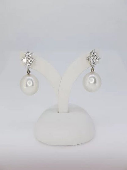 South Sea Pearl and Diamond Drop Earrings; featuring 13.5mm South Sea pearls suspended from diamond-set quatrefoil studs, 1.04 carat total, in 18ct white gold