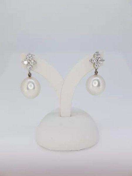South Sea Pearl and Diamond Drop Earrings; featuring 13.5mm South Sea pearls suspended from diamond-set quatrefoil studs, 1.04 carat total, in 18ct white gold