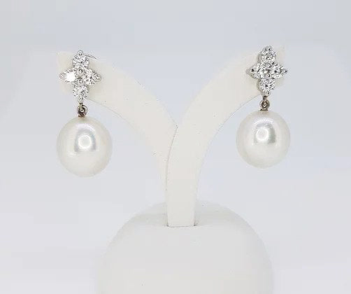 South Sea Pearl and Diamond Drop Earrings; featuring 13.5mm South Sea pearls suspended from diamond clusters, 1.04 carats, in 18ct white gold