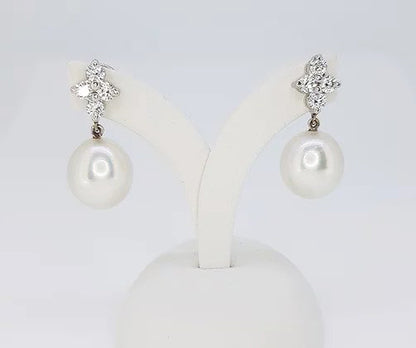 South Sea Pearl and Diamond Drop Earrings; featuring 13.5mm South Sea pearls suspended from diamond clusters, 1.04 carats, in 18ct white gold