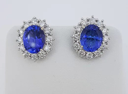 Tanzanite and Diamond Oval Cluster Stud Earrings; 5.21cts oval tanzanites surrounded by 1.75cts brilliant-cut diamonds, 18ct white gold